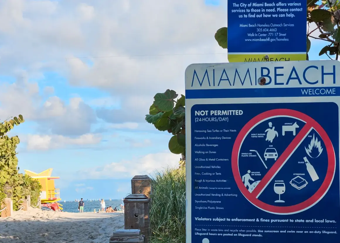 Tablica informacyjna na plaży w Miami Beach, gdzie leży to słynne miasto. Widać zakazy, np. alkoholu i plastikowych słomek.