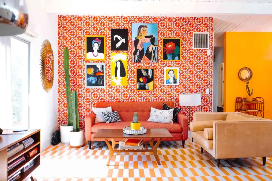 Vibrant living room with a bold 70s aesthetic. Orange patterned wallpaper, a cactus, and colorful art create a retro vibe.