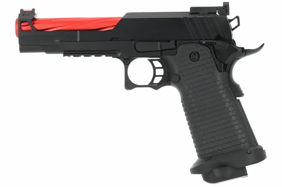 Pistola negra con cañón rojo, lista para el vuelo del águila dorada.