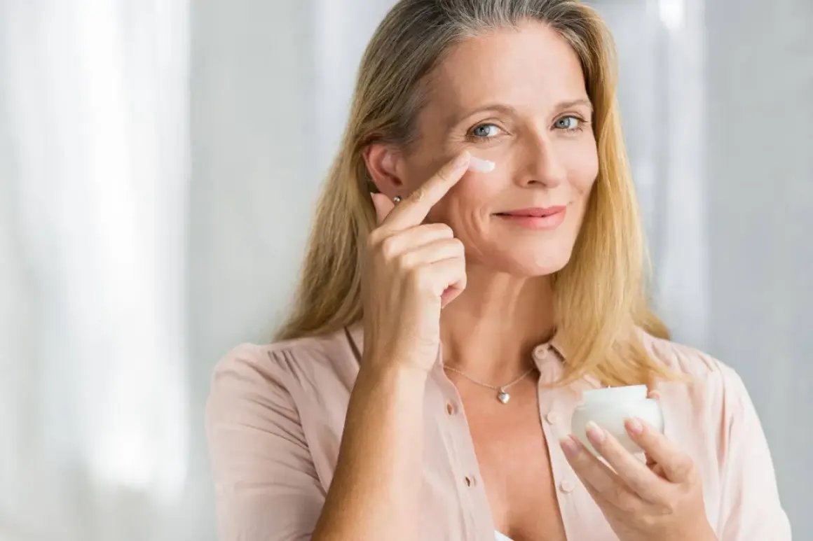 Frau trägt Vitamin A Kosmetik auf, um ihre Haut zu pflegen.