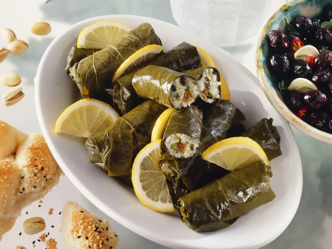 Gefüllte Weinblätter, ein köstliches Dolmades Rezept, serviert mit Zitronenspalten und Oliven.