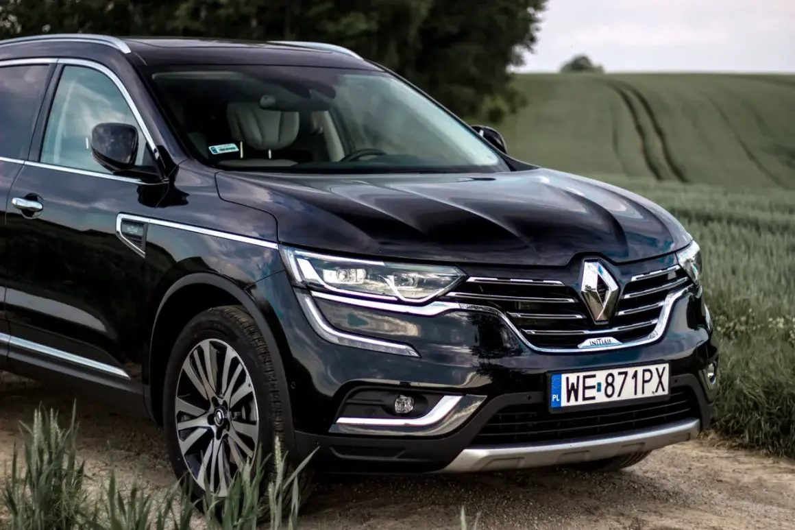 Czarny Renault Initiale na tle zielonych pól. Elegancki SUV z chromowanymi detalami i nowoczesnymi światłami.