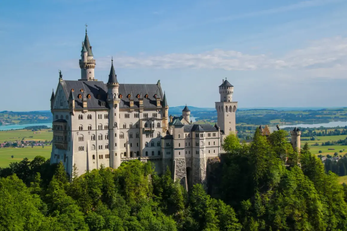 Schloss Neuschwanstein, ett sagoslott i Bayern, reser sig majestätiskt över en grönskande skog.