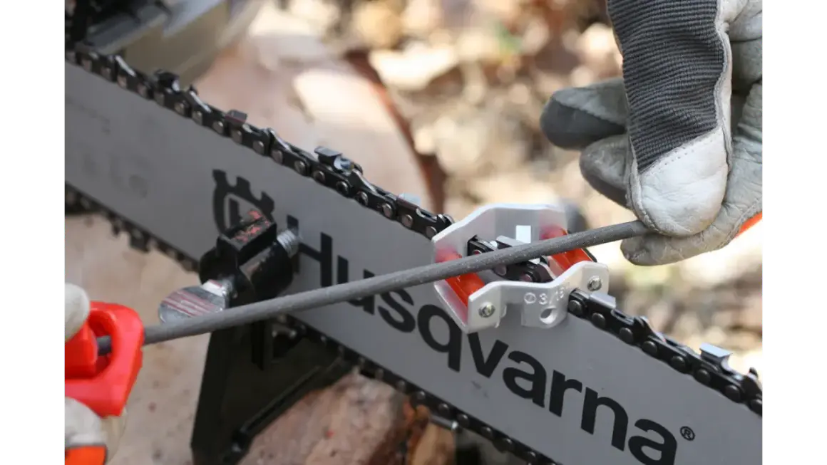 Ostrzenie łańcucha pilarki Husqvarna. Użyj prowadnicy do pilnika, by zachować właściwy kąt ostrzenia.