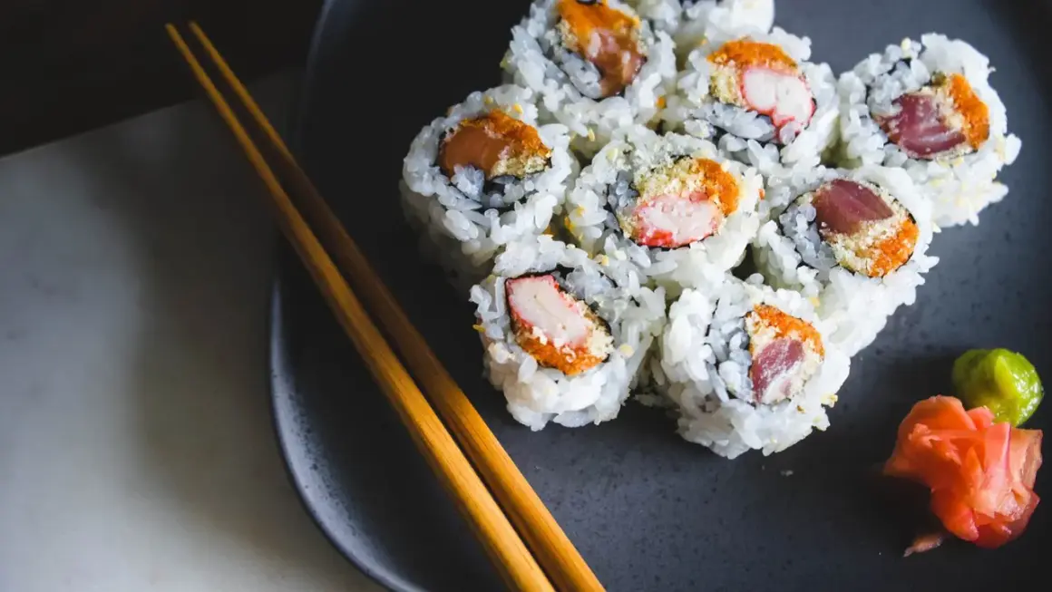 Talerz z sushi, pałeczki i dodatki. Zastanawiasz się nad sushi kcal? Smacznego!