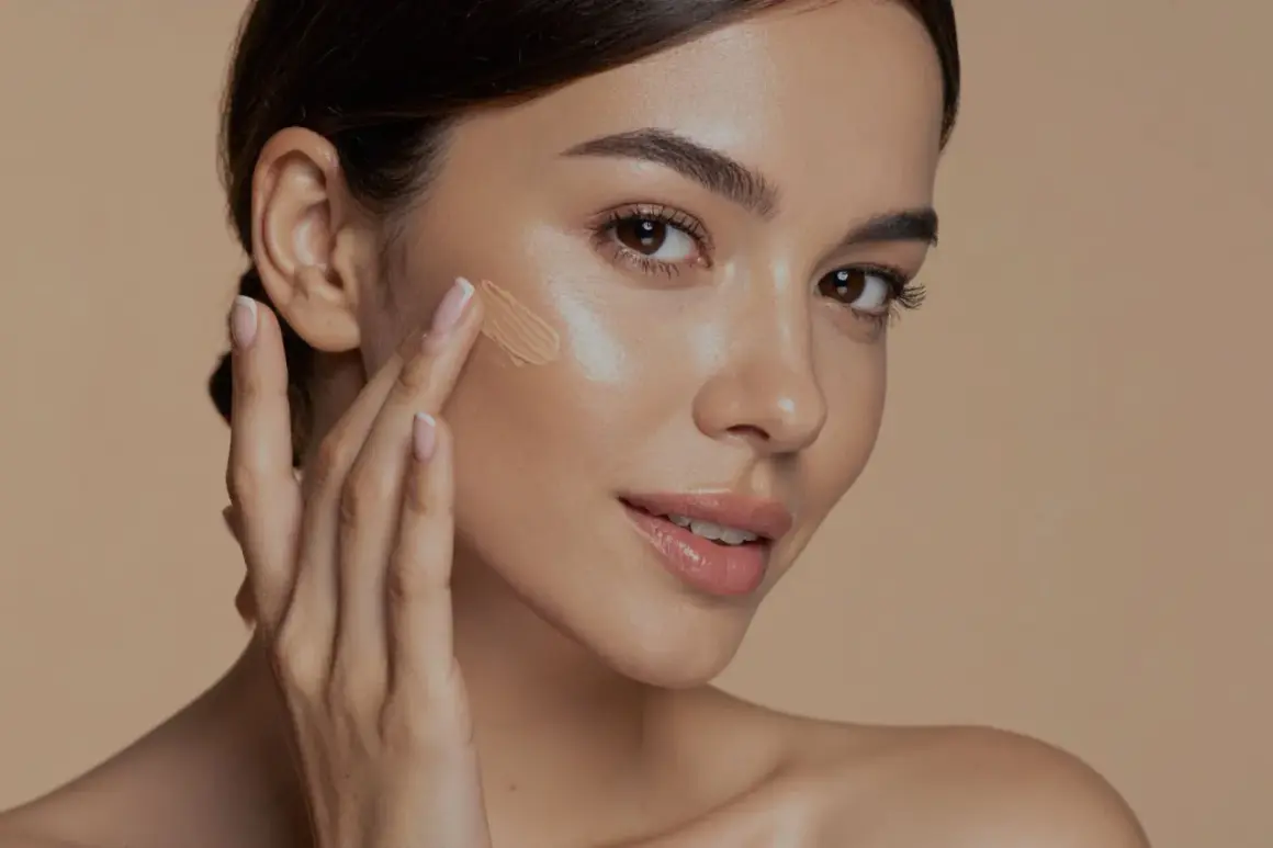 Donna applica il fondotinta con le dita, mostrando come si mette il fondotinta per un look naturale.