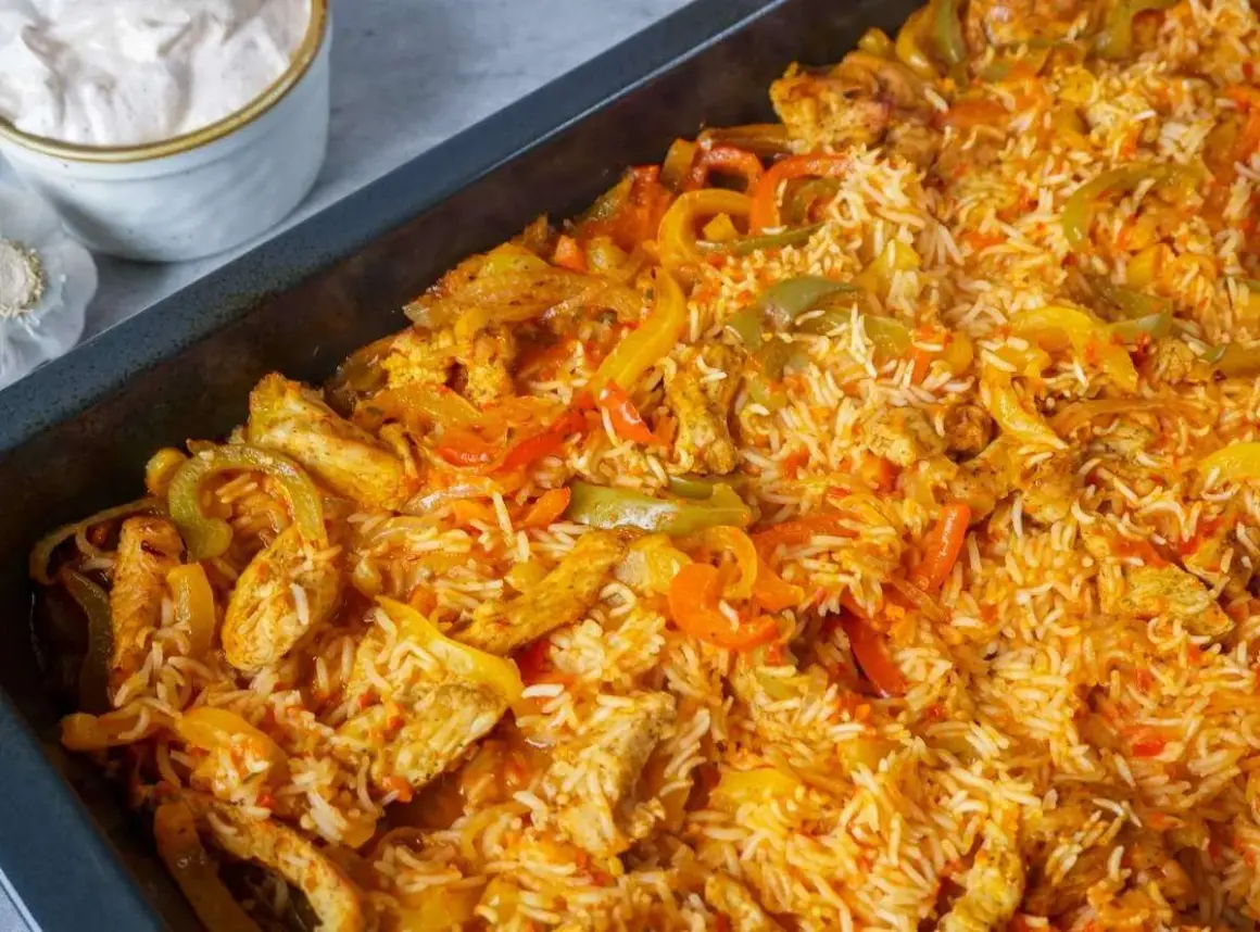 Reis im Backofen mit Hähnchenstreifen und bunten Paprikastreifen. Eine köstliche Mahlzeit, die im Ofen zubereitet wird.