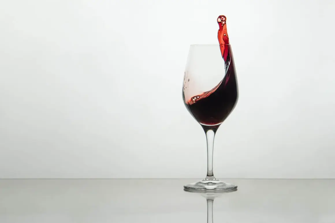 Ein Glas Rotwein mit einer dynamischen Welle, die die Frage aufwirft, wie schmeckt wein.