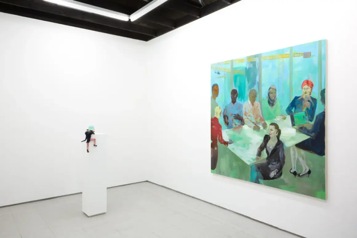 A miniature figure climbs a pedestal in a white-walled gallery, a vibrant painting of a diverse group at a meeting hangs nearby. NYC galleries for emerging artists showcase such intriguing pieces.