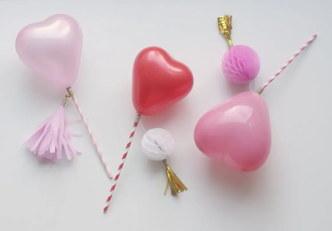Balony w kształcie serc na patyczkach z ozdobami.