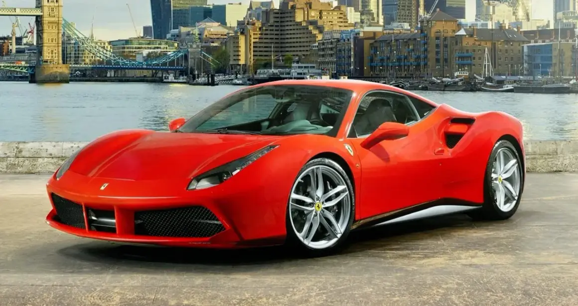 Czerwone Ferrari 488 GTB z dumą prezentuje się na tle Londynu, z Tower Bridge w tle.