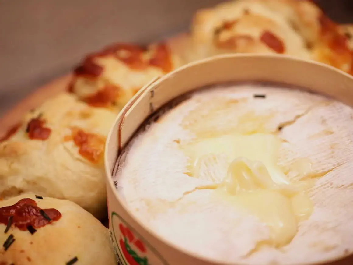 Un Mont d'Or fondant, prêt à être dégusté avec du pain croustillant. Parfait pour un repas convivial.