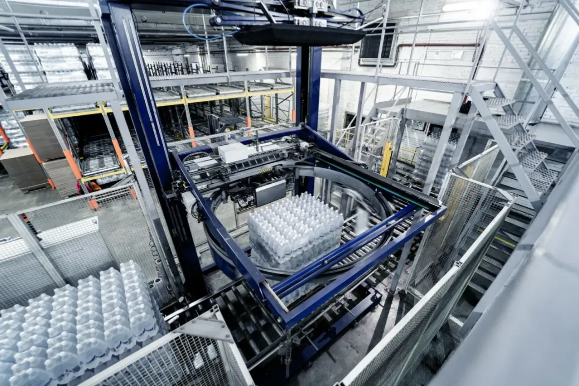 Automatyczny system pakowania butelek z wodą w nowoczesnym gnieździe produkcyjnym.
