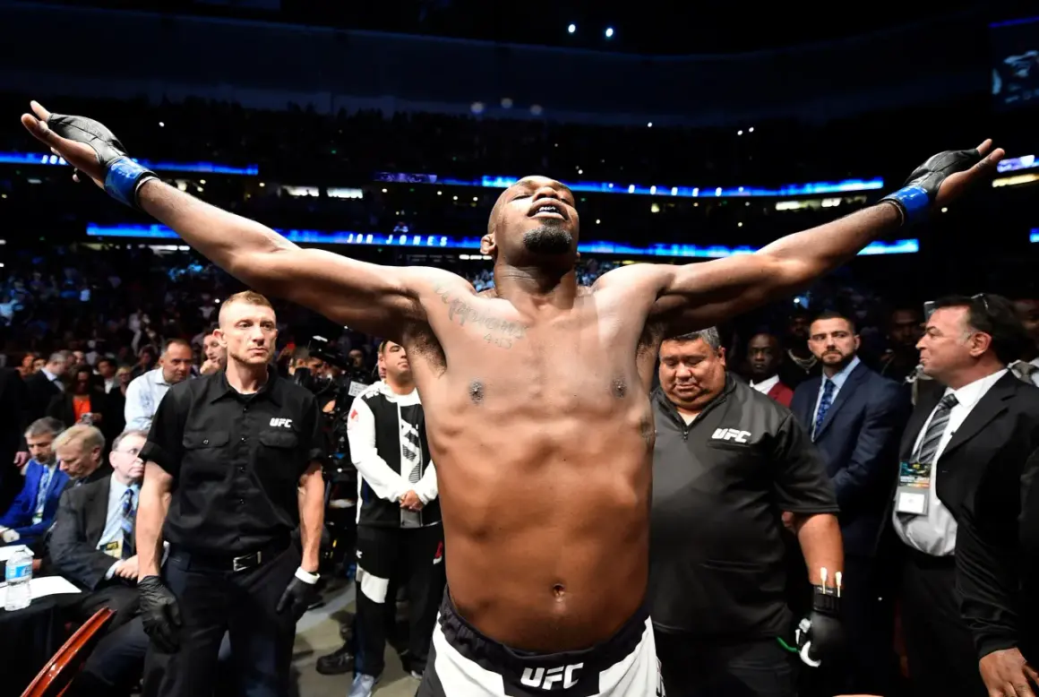 Jon Jones firar sin seger vid UFC 285 med armarna utsträckta inför publiken.