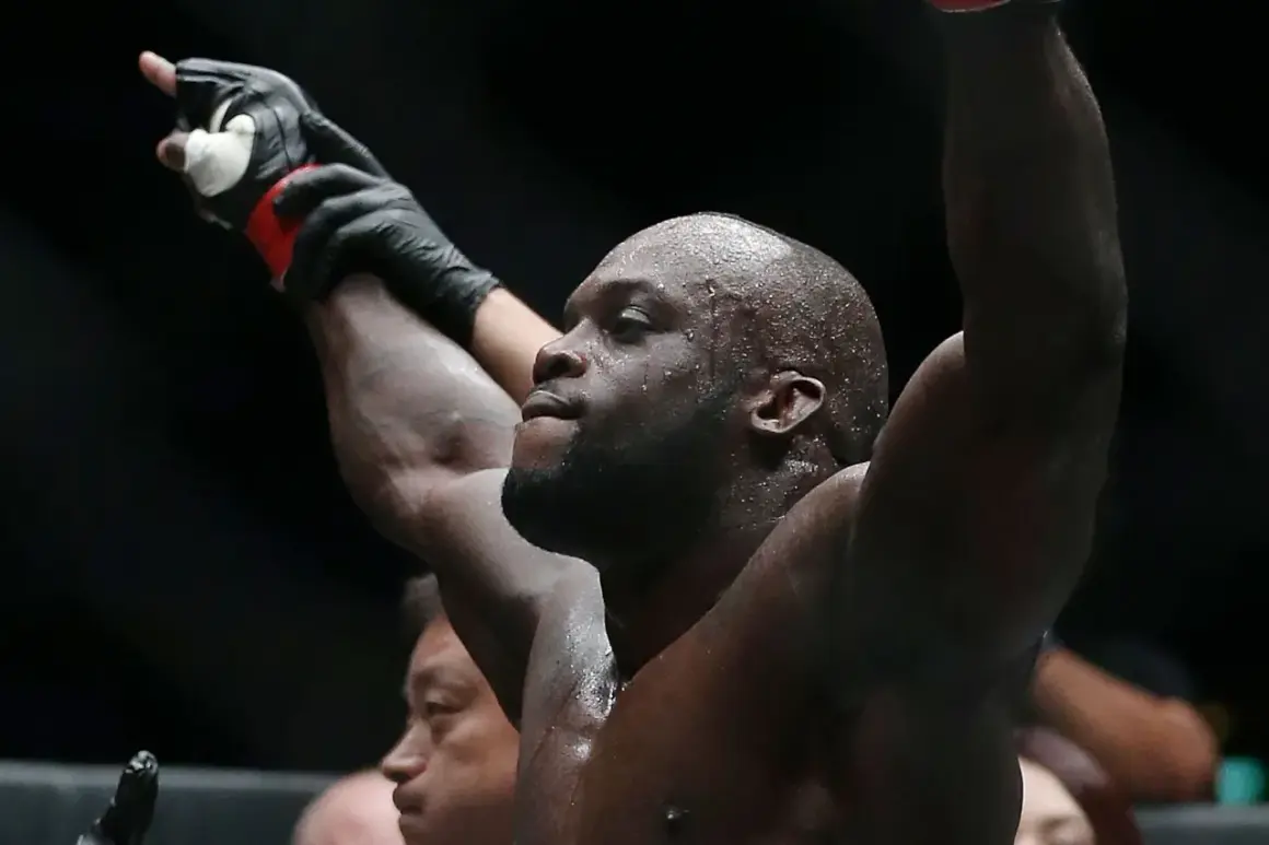 Melvin Manhoef, svettig och med armarna i luften, firar en seger.