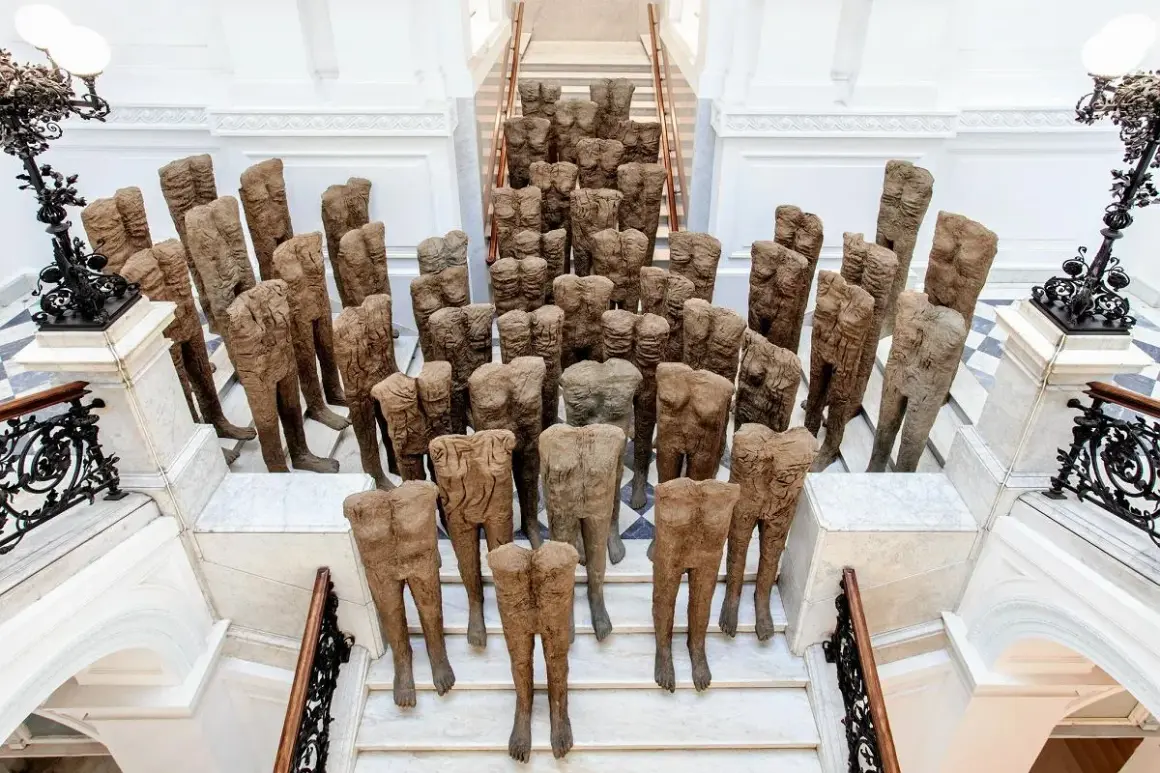 Tłum postaci ludzkich, dzieło Magdaleny Abakanowicz, schodzi po schodach.