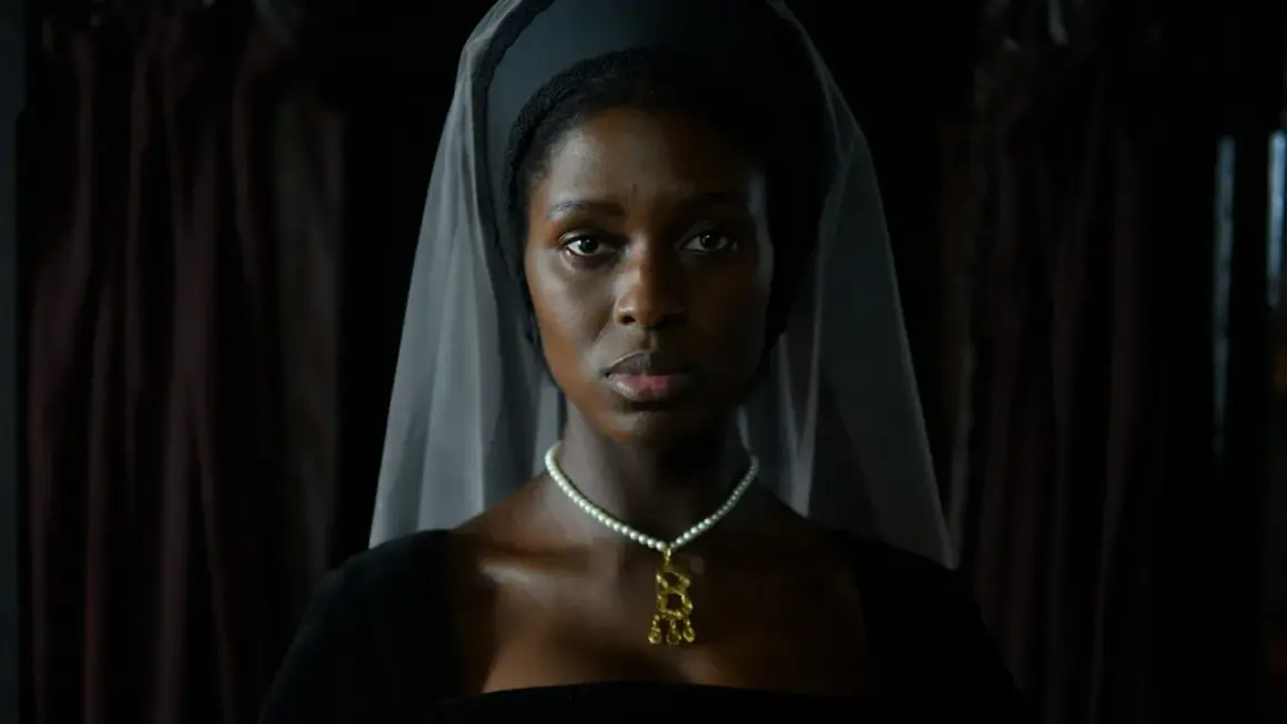 En kvinna i historisk dräkt, med slöja och pärlhalsband, i en scen från anne boleyn series.