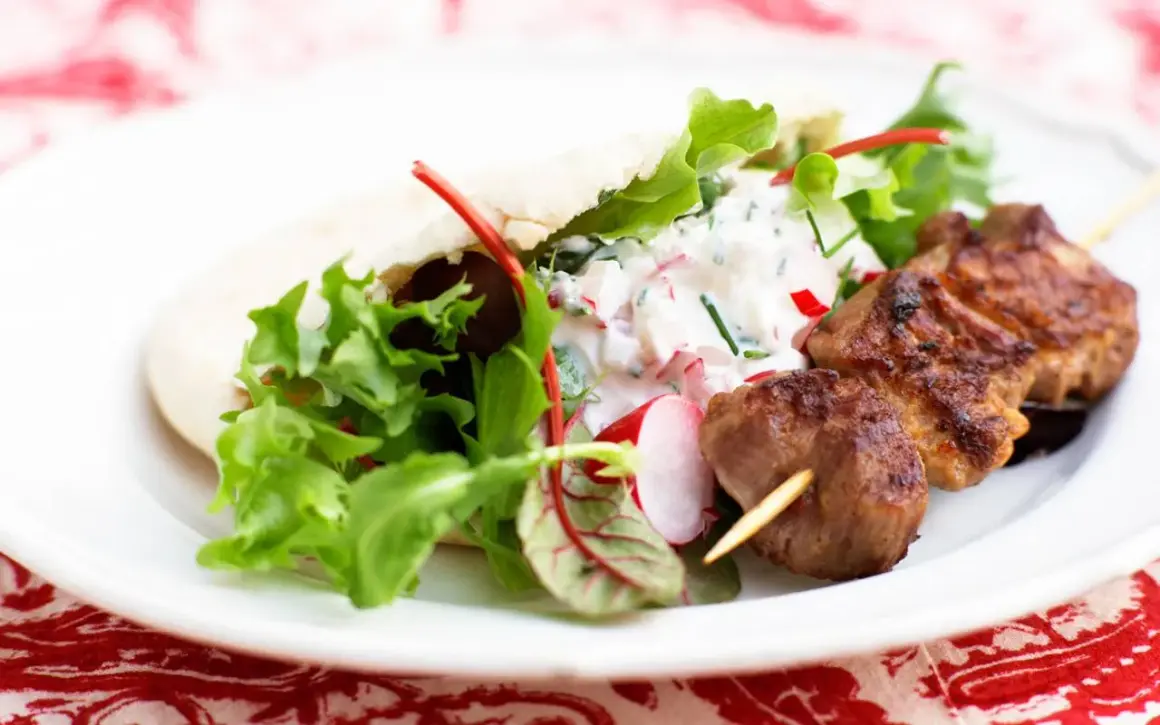 Saftiga kebabspett i ugn serveras med pitabröd, fräsch sallad och en krämig yoghurtsås med rädisor. En perfekt middag!