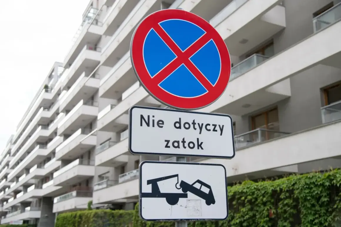 Znak zakazu zatrzymywania (B-36) z tabliczką "Nie dotyczy zatok" i piktogramem lawety odholowującej auto.