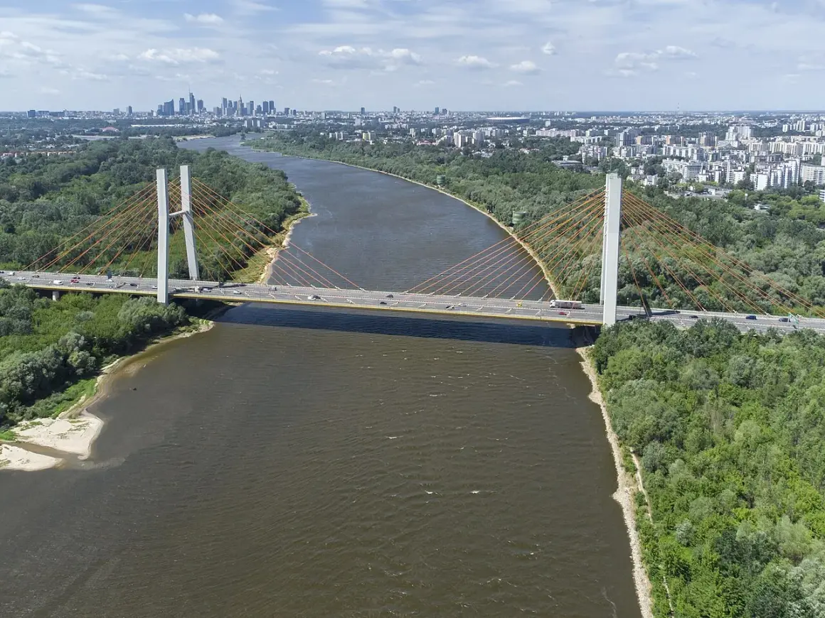 Most Siekierkowski w Warszawie nad Wisłą, z widokiem na panoramę miasta i zielone brzegi.