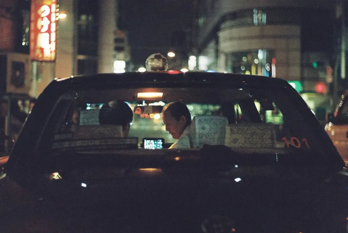 Taxi driver illuminated by a phone screen, a perfect shot for the best 35mm film for low light.