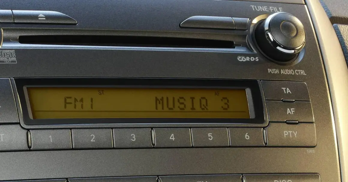 Radio samochodowe z wyświetlaczem RDS, pokazującym FM1 i MUSIQ 3. Przyciski numeryczne i sterowanie audio.