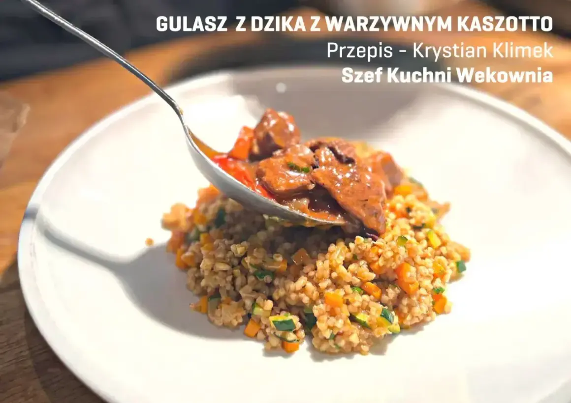 Gulasz z dzika z kaszotto warzywnym. Łyżka nakłada aromatyczne mięso na talerz pełen zdrowego kaszotto.