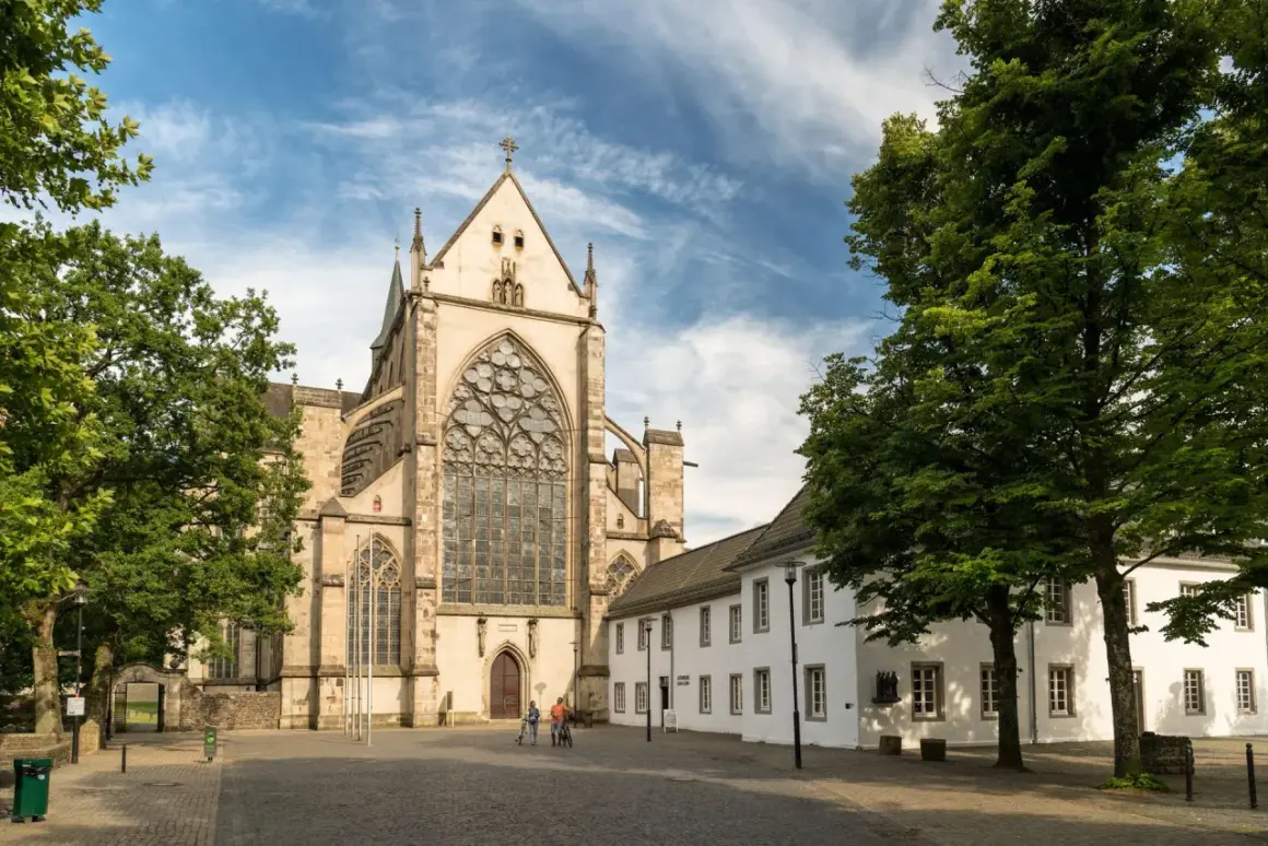 Ein Paar radelt am Münster vorbei, einem der beeindruckendsten bergisch gladbach sehenswürdigkeiten.
