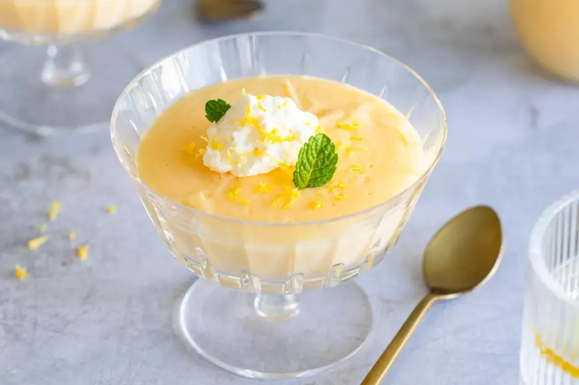 Cremiges Lemon Curd Dessert im Glas, garniert mit Sahne, Minze und Zitronenschale. Perfekt für ein einfaches Lemon Curd Rezept.