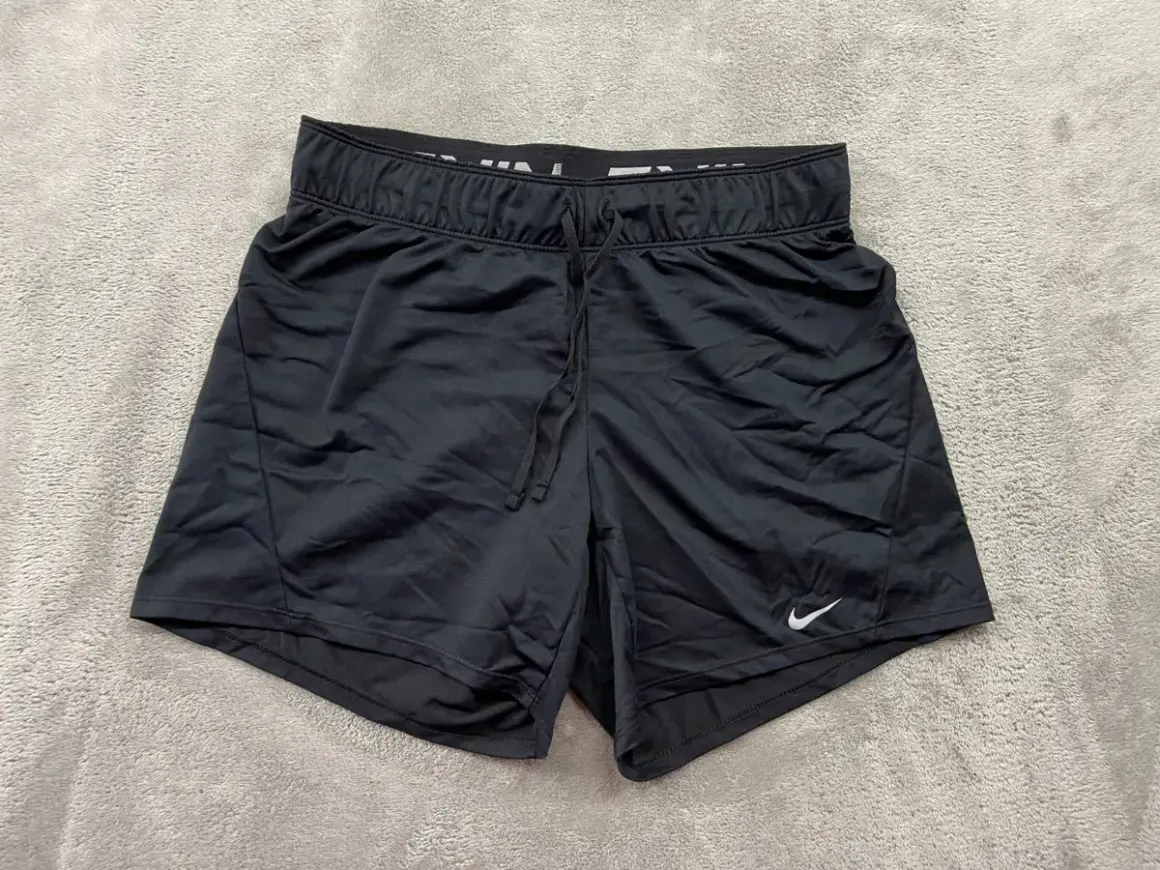 Czarne spodenki Nike Dri-Fit damskie, idealne na trening. Elastyczny pas i sznurek zapewniają komfort.