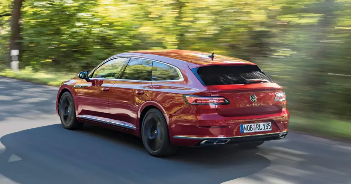 Czerwony Volkswagen Arteon Shooting Brake w ruchu na tle rozmytego krajobrazu.
