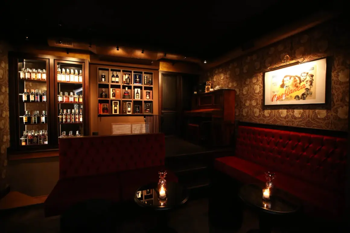 Atmosfera elegante con divani rossi, pianoforte e scaffali pieni di bottiglie. Un locale che potrebbe essere tra i migliori club di Napoli.