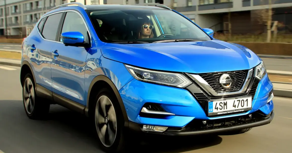 Niebieski Nissan Qashqai w ruchu. Kierowca w okularach przeciwsłonecznych. Sprawdź nissan qashqai wymiary.