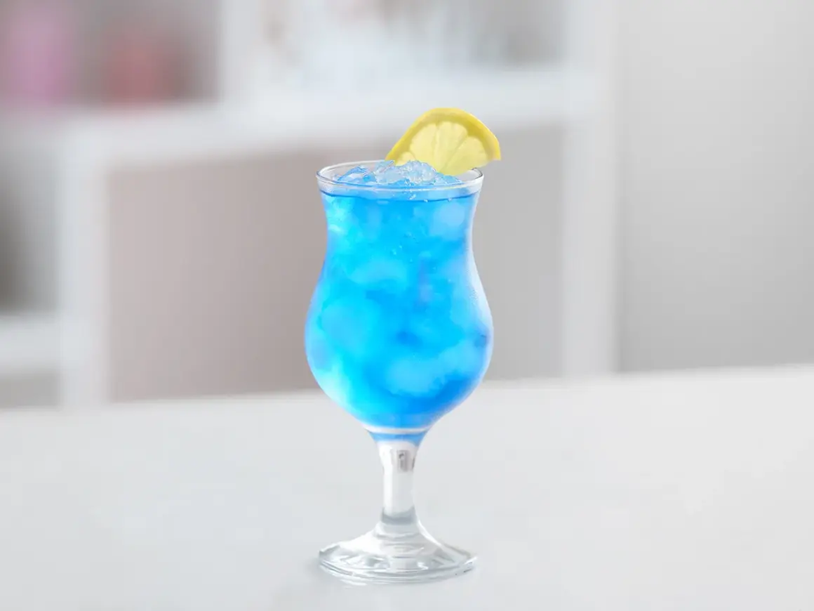 Erfrischender Blue Lagoon Cocktail mit Eis und Zitronenscheibe. Perfekt für dein Blue Lagoon Cocktail Rezept.