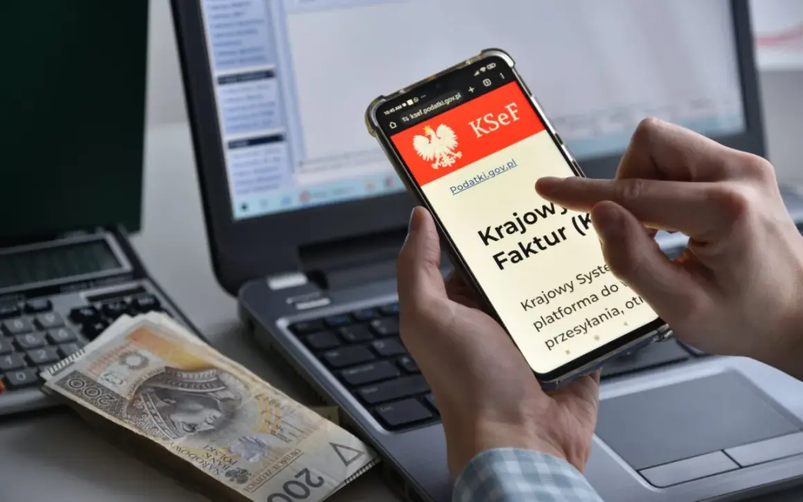 Dłoń trzyma smartfon z ekranem KSeF, obok leżą pieniądze i kalkulator.