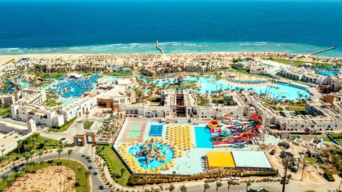 Widok z lotu ptaka na kompleks hotelowy Pickalbatros Oasis Port Ghalib z basenami, zjeżdżalniami i plażą nad Morzem Czerwonym.