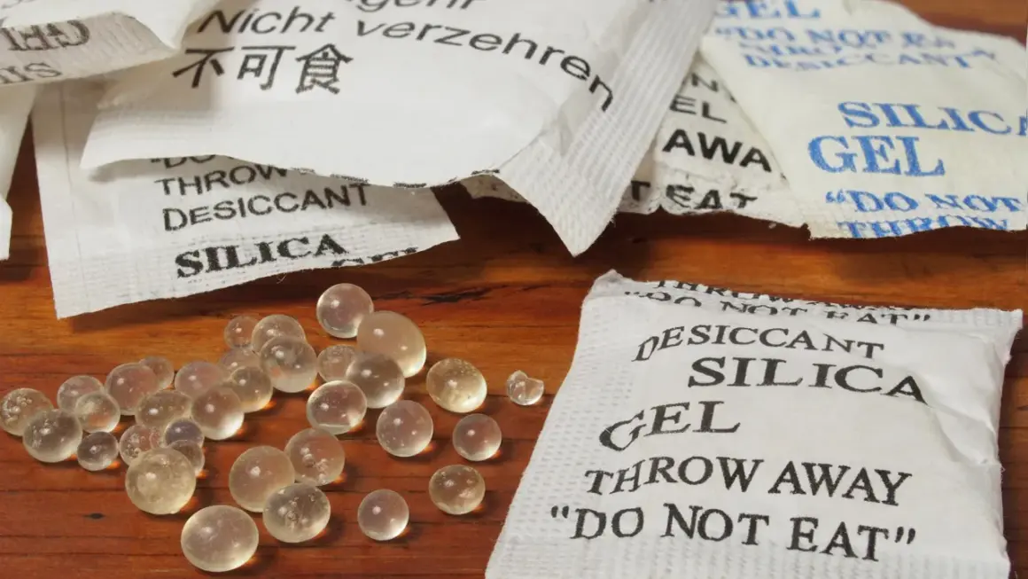 Silica-Gel-Beutel und Kügelchen, die Feuchtigkeit absorbieren. Was ist Silica? Ein Trockenmittel, das vor Nässe schützt.