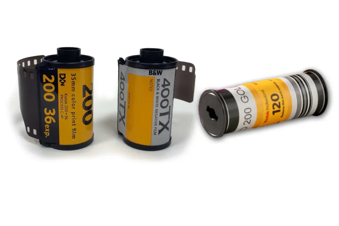 Tre filmrullar: en 35mm färgfilm, en 35mm svartvit film och en 120-film. Dessa visar hur framkallar man bilder från analog film.
