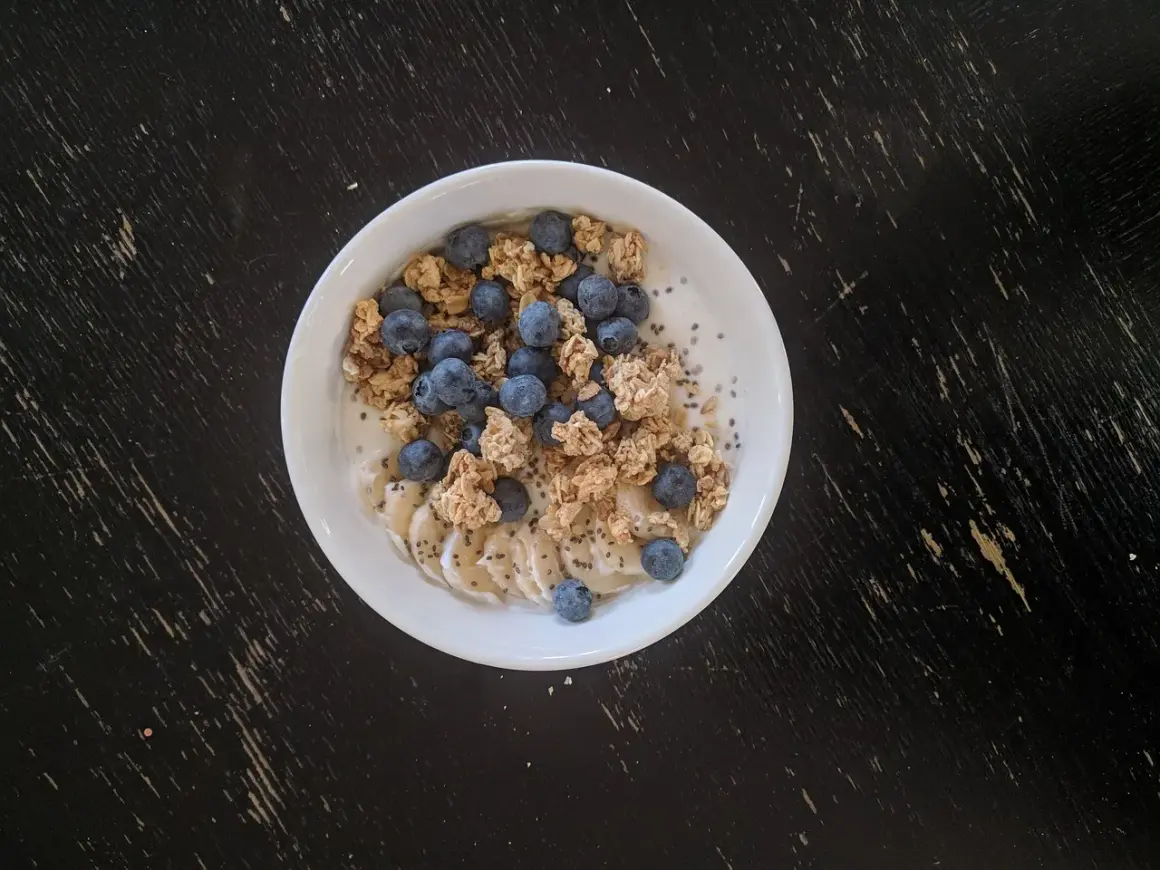 Un bol de skyr avec des myrtilles, des rondelles de banane et du granola. On peut chauffer le skyr pour un petit-déjeuner réconfortant.