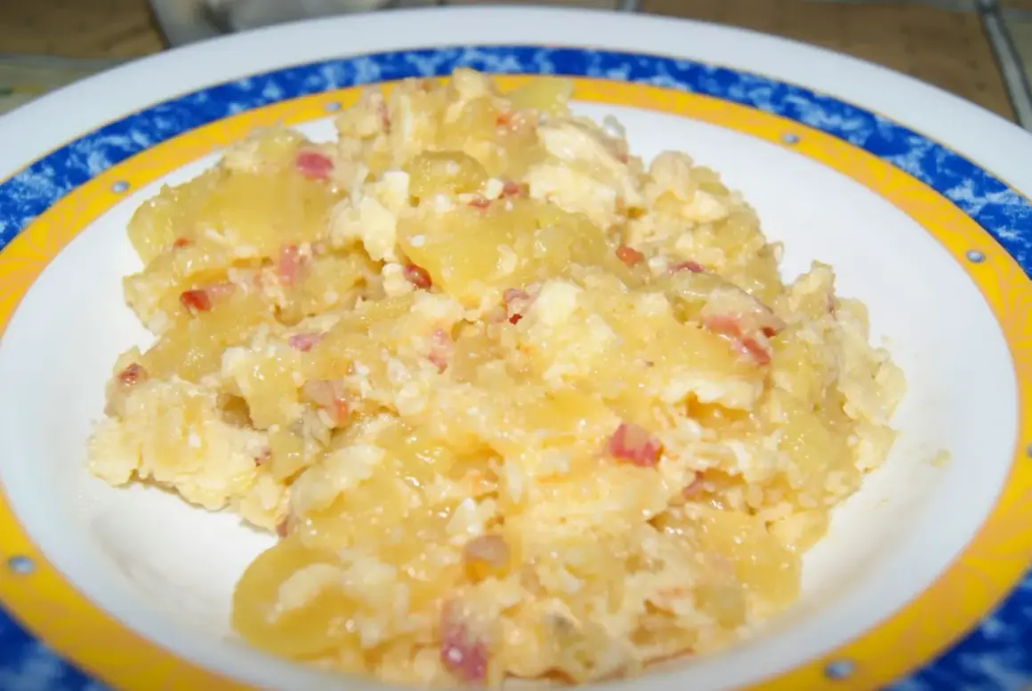 Patatas revueltas con huevo y trocitos de bacon, un plato casero delicioso y reconfortante.