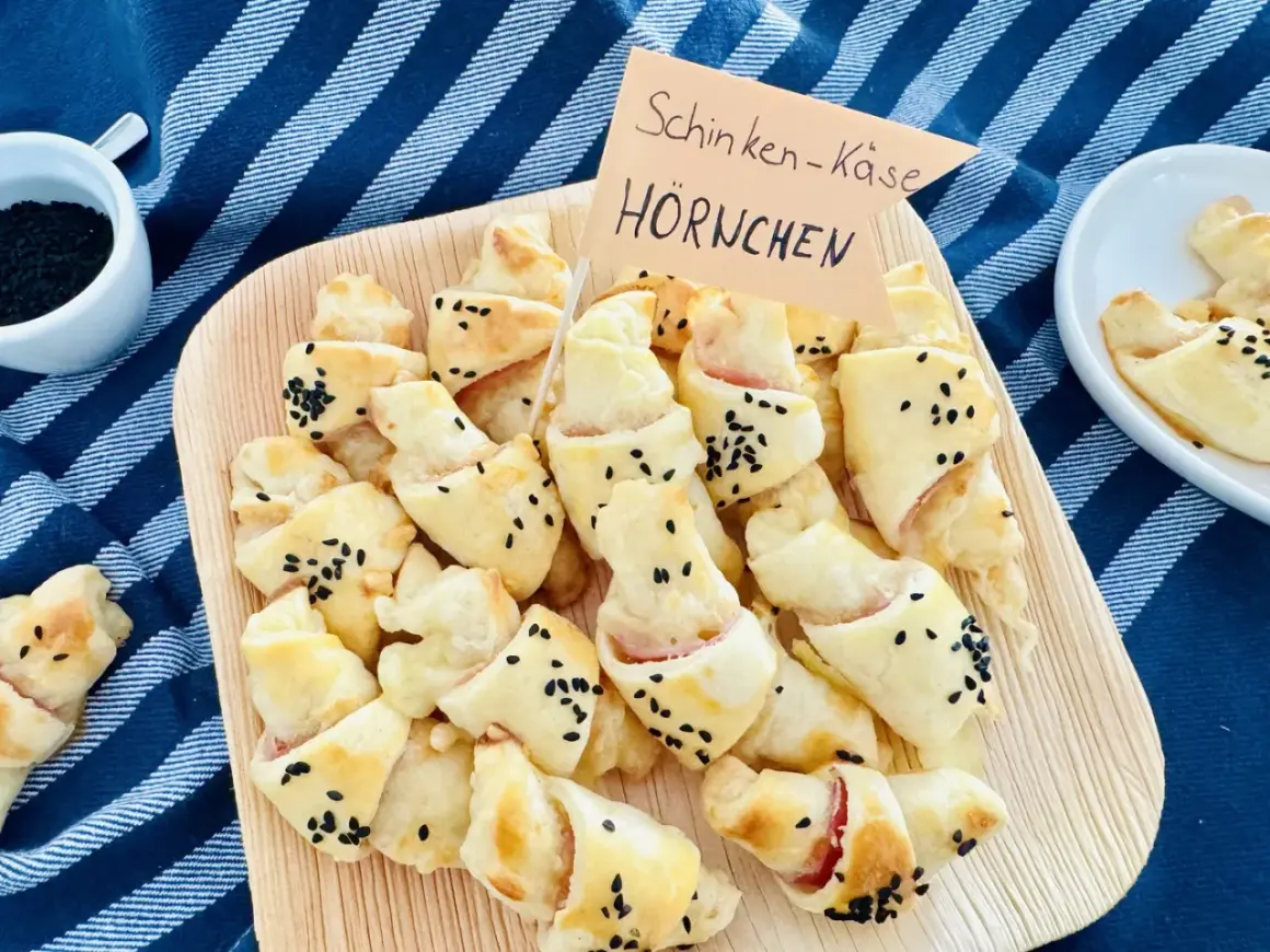 Schinken-Käse-Hörnchen, perfekt für ein karneval buffet kinder. Goldbraun gebacken, bestreut mit schwarzen Sesamkörnern.