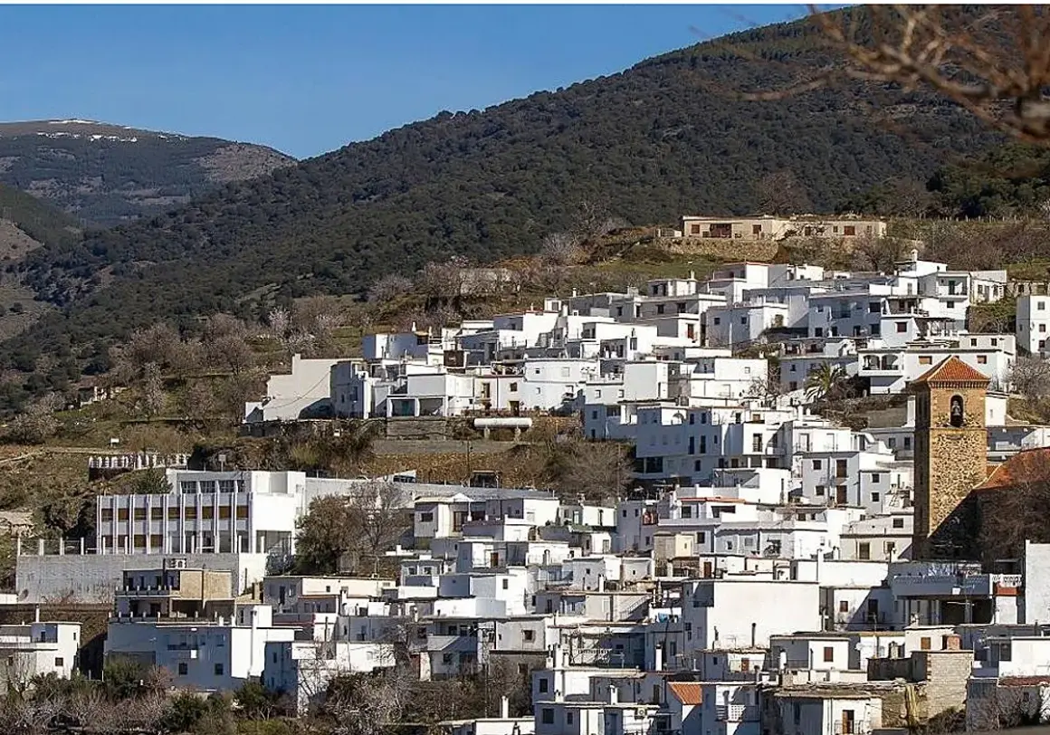 Pueblo blanco en ladera montañosa, ideal para saber qué ver en Almería capital. Destaca su torre campanario.