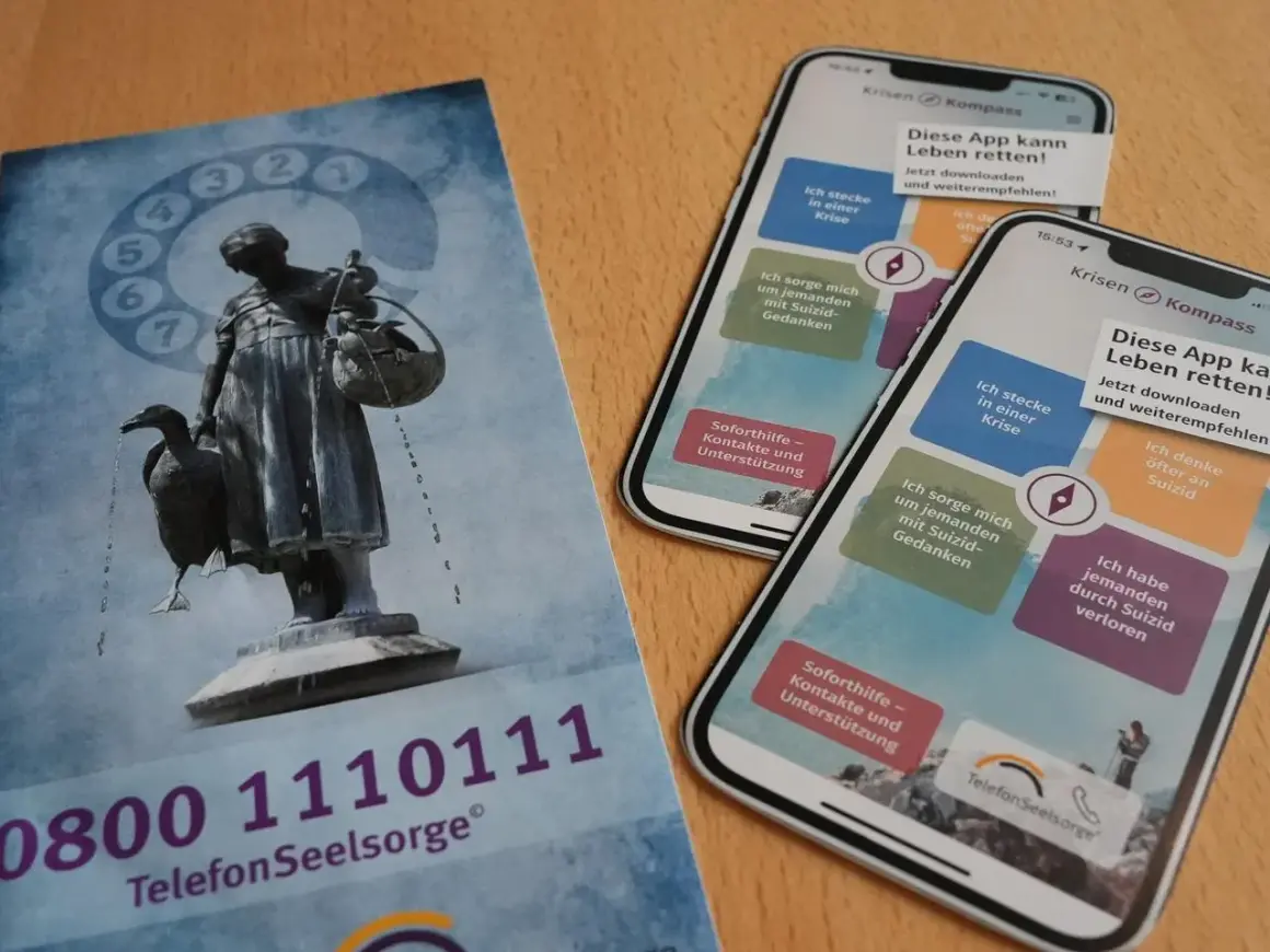 Flyer und Smartphones mit der App "Krisen Kompass" zeigen Wege zur rettung aus der not. Die Telefonseelsorge bietet Hilfe.