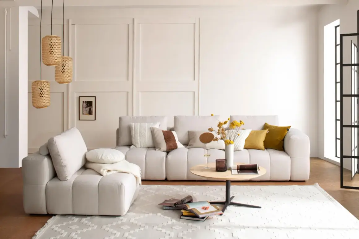 Helles Wohnzimmer mit beigem Sofa, Korb-Pendelleuchten und einem runden Couchtisch. Die Einrichtung folgt Feng Shui Regeln für Harmonie.