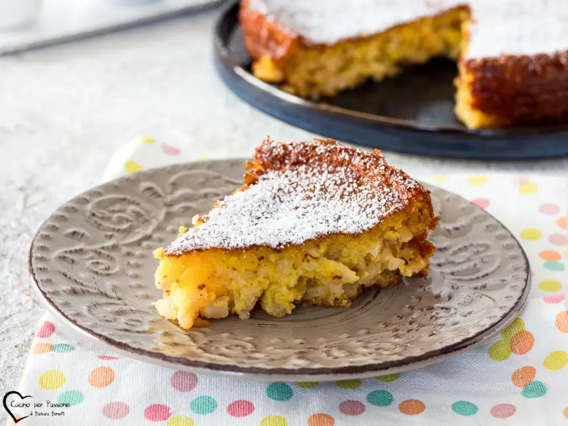 Una fetta di torta di riso, la ricetta della nonna, cosparsa di zucchero a velo su un piatto grigio.