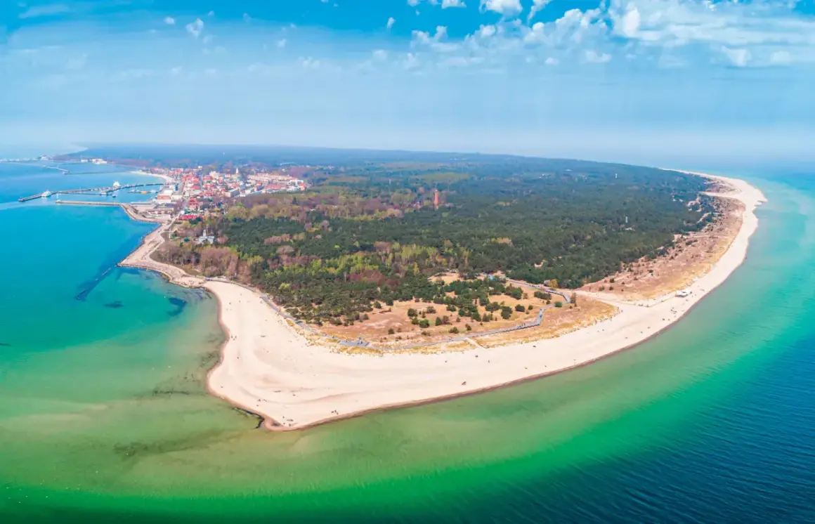 Półwysep Helski zachwyca szerokością plaż i lasów. Widok na miasteczko i turkusowe morze.