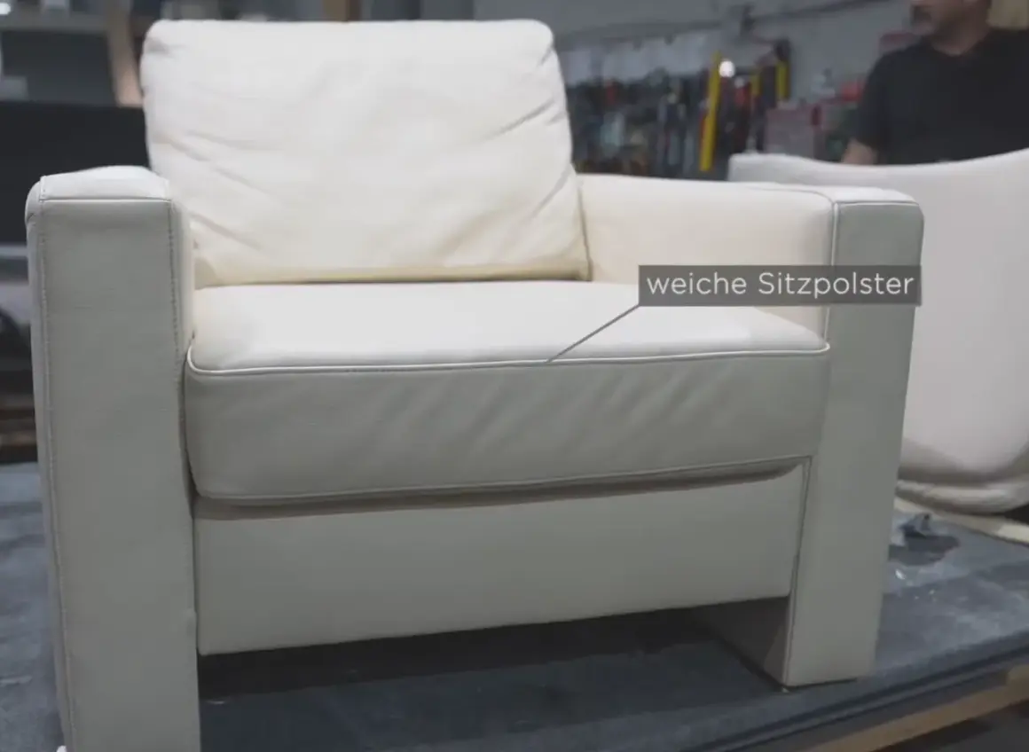 Ein weißer Ledersessel mit weichen Sitzpolstern. Hier wird gezeigt, wie man den Federkern eines Sofas reparieren kann.