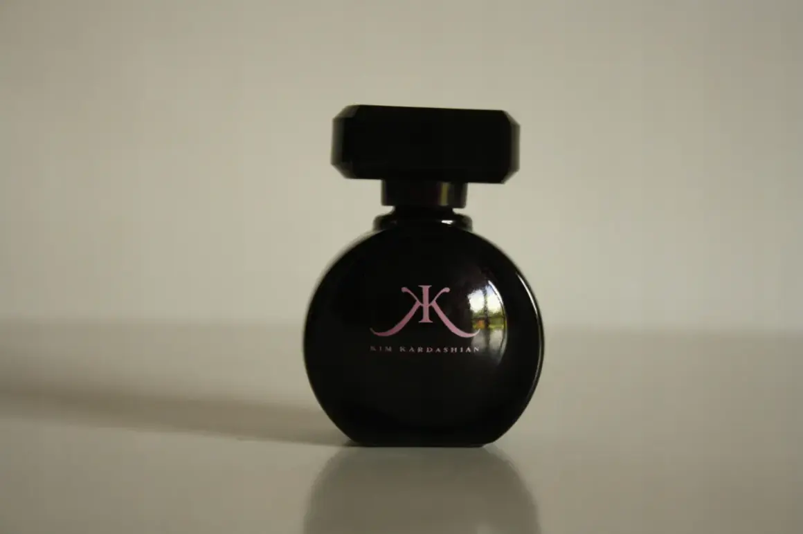 Czarna butelka perfum Kim Kardashian z różowym logo.
