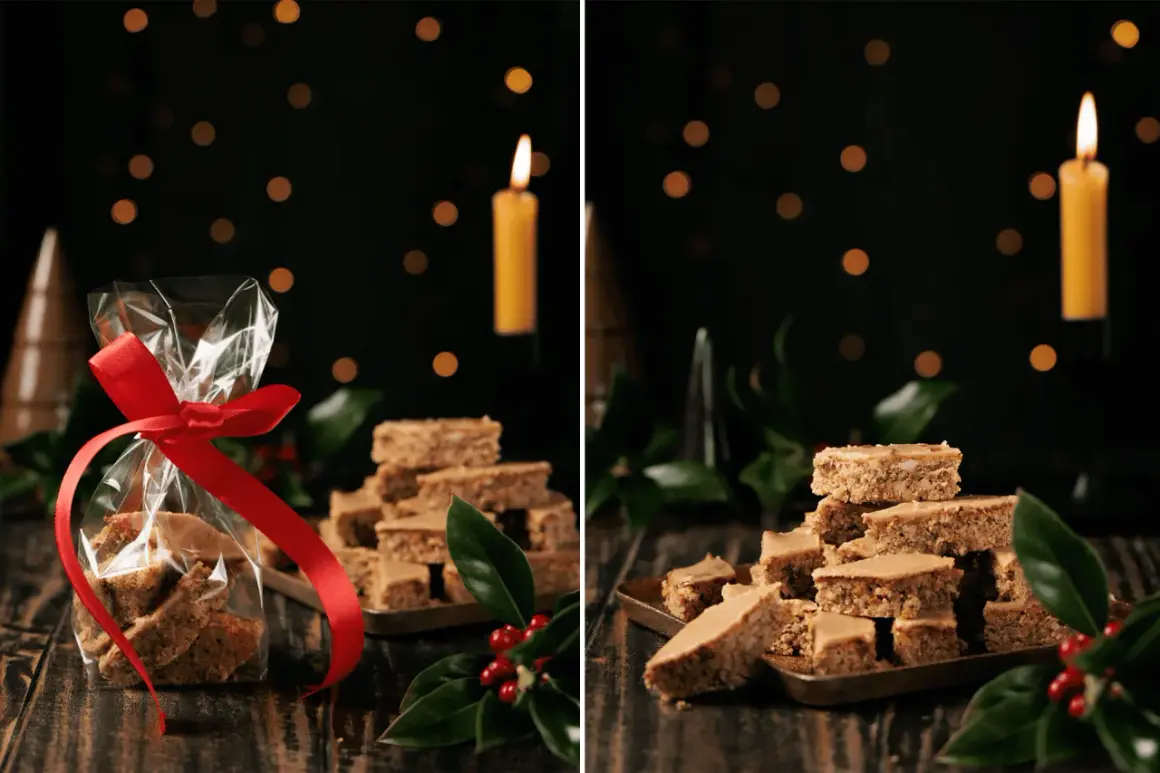Weihnachtliche Elisenlebkuchen vom Blech, liebevoll verpackt und auf einem Blech gestapelt, mit Kerzenlicht und Tannenzweigen.