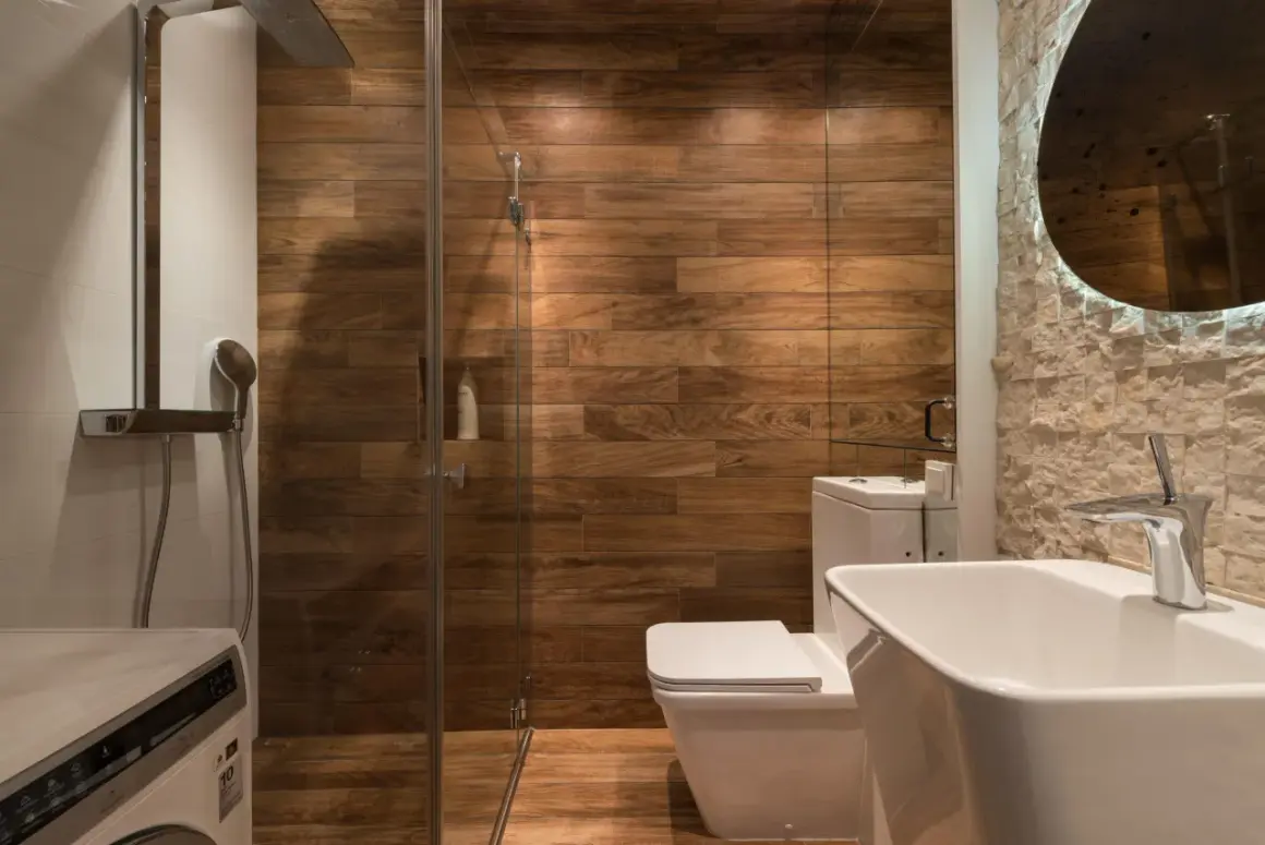 Moderno baño con ducha de cristal, paredes de madera y lavabo. ¿Cuánto cuesta cambiar bañera por plato de ducha?